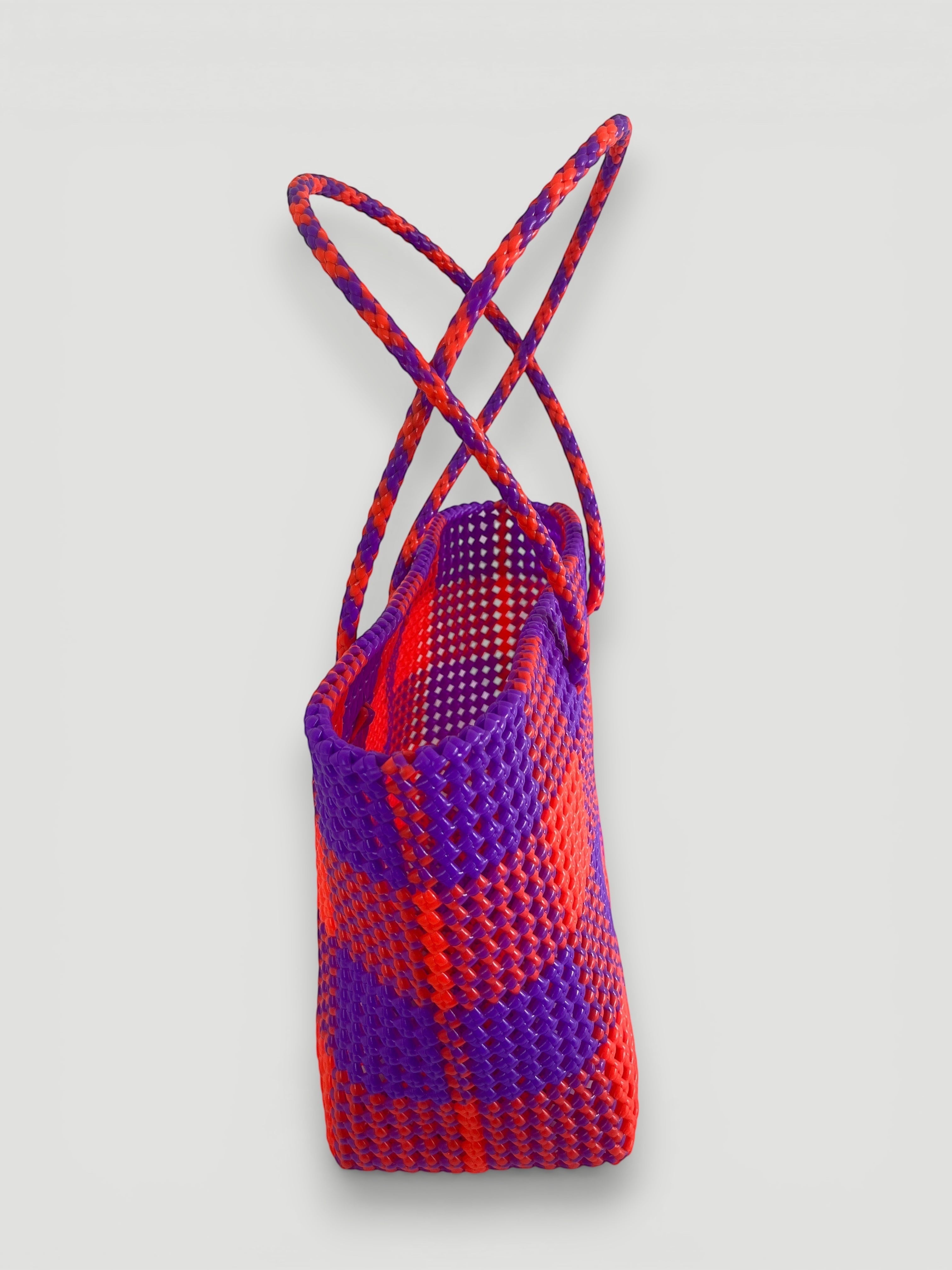 MOKA large handmade woven tote bag in purple and fluorescent orange recycled plastic and silk. Features braided handles and a unique, durable design.